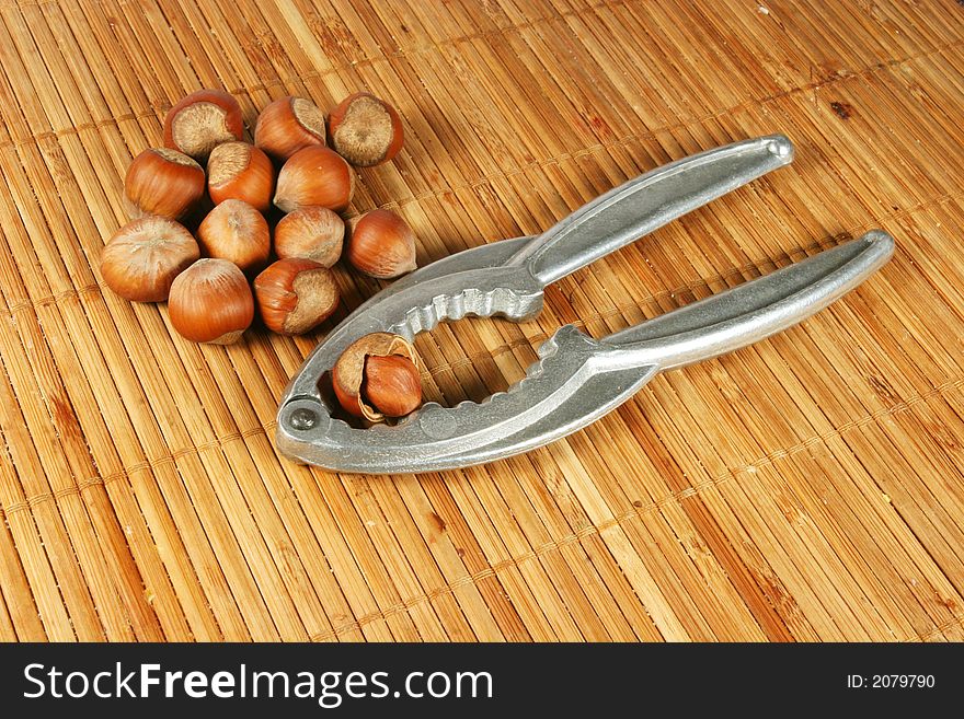 Nutcracker and hazel nuts on a bamboo background