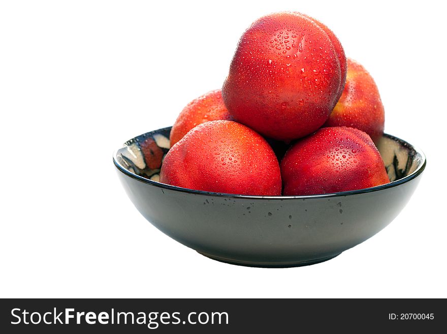 A bowl full of nectarines. The nectarines are fresh, wet, vibrant and juicy. A bowl full of nectarines. The nectarines are fresh, wet, vibrant and juicy.