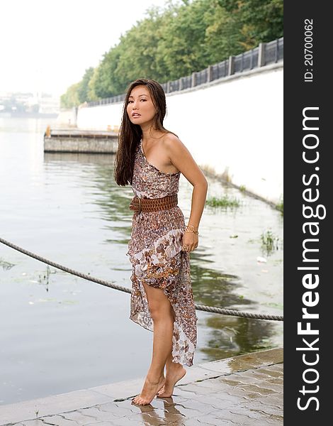 Beautiful girl walking near river in summer