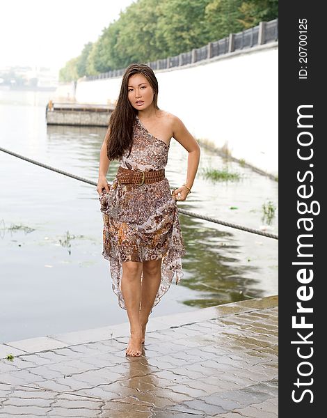 Beautiful girl walking near river in summer