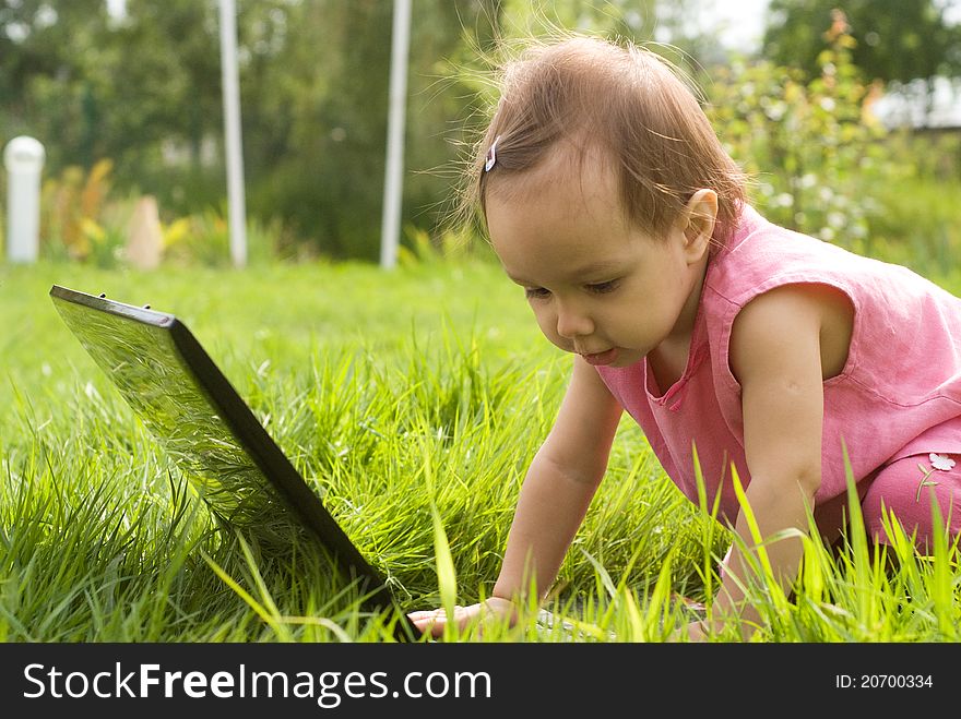 Little girl with a laptop at nature. Little girl with a laptop at nature