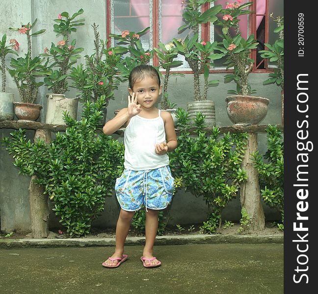 Philippines girl posing smiling and holding three fingers up and mandarin. Philippines girl posing smiling and holding three fingers up and mandarin