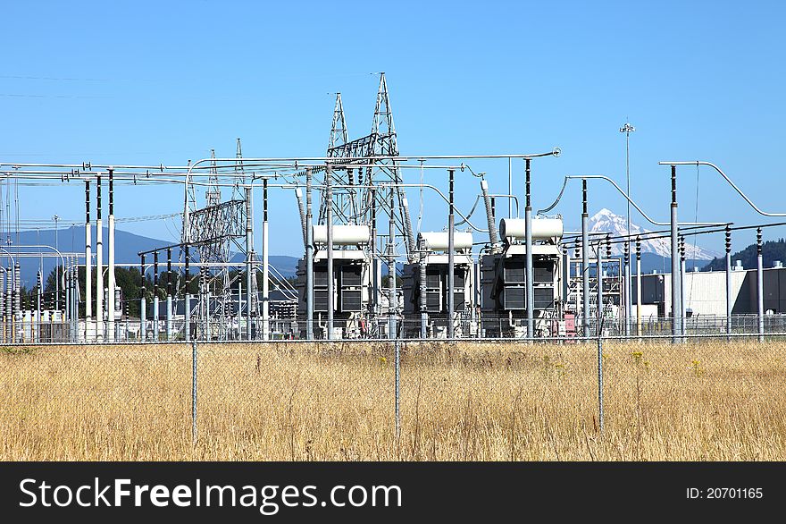 Tall towers distributing power-lines to various directions in an open field. Tall towers distributing power-lines to various directions in an open field.