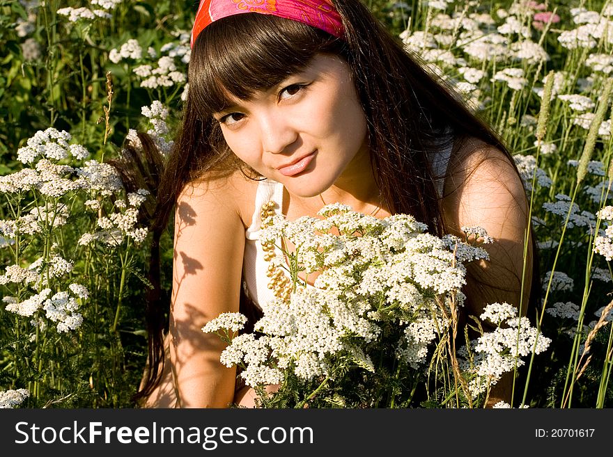 Beautiful girl sitting on meadow