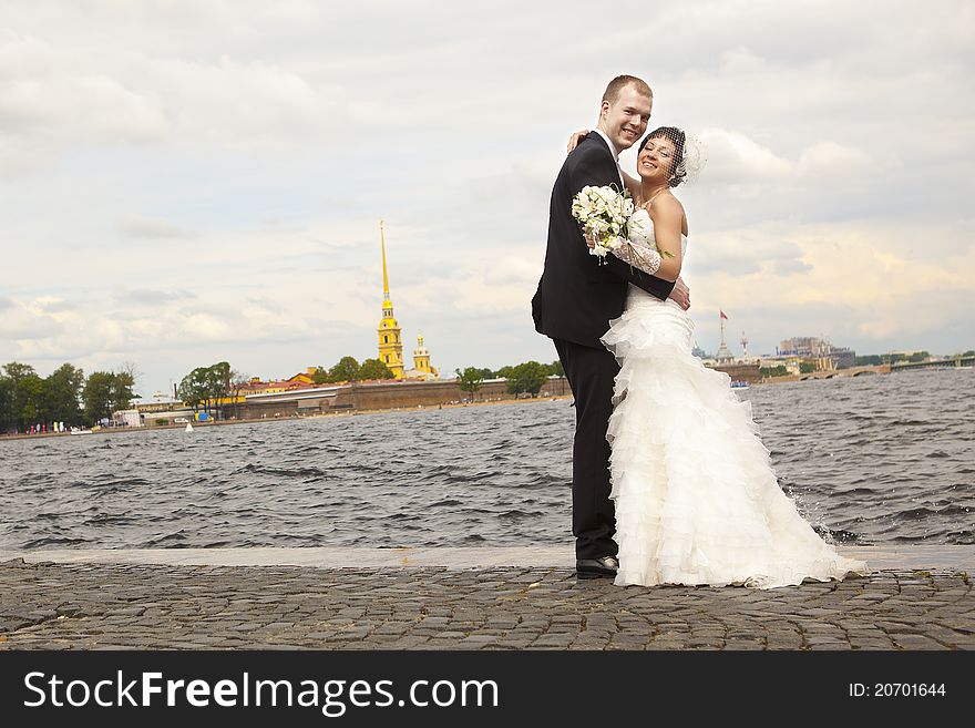 Bride and groom walking on the waterfront. Bride and groom walking on the waterfront