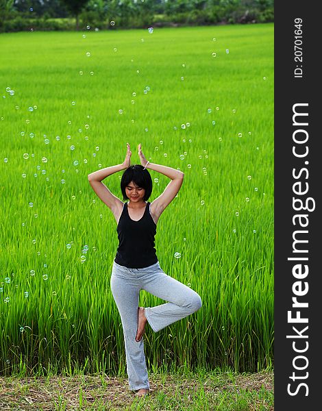 Girl practicing yoga, standing in paddy field. Girl practicing yoga, standing in paddy field