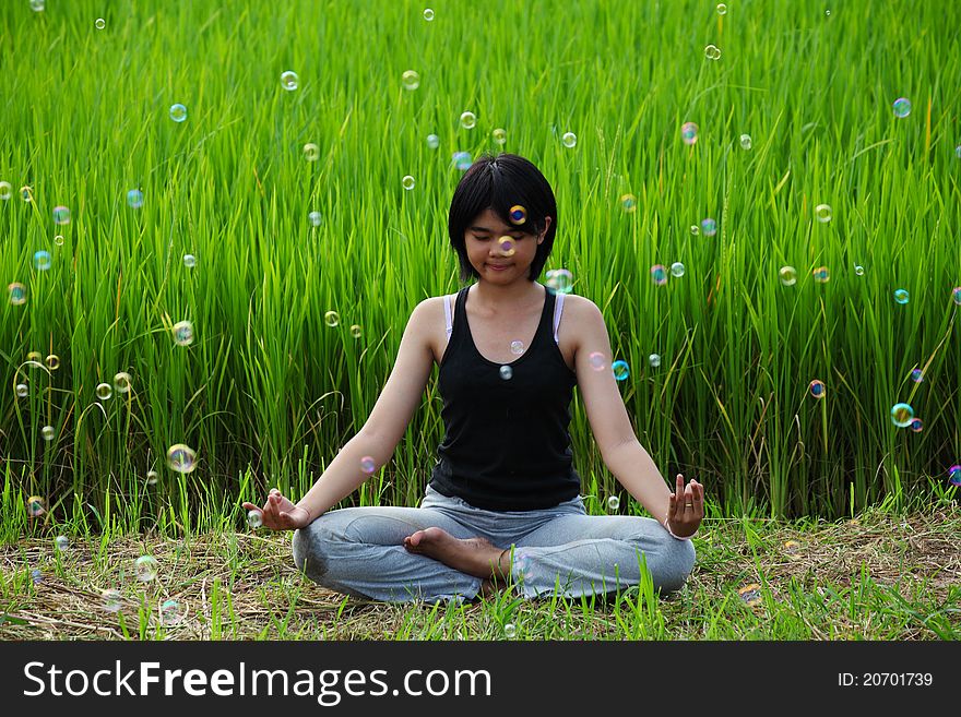 Girl practicing yoga, sitting in paddy field. Girl practicing yoga, sitting in paddy field