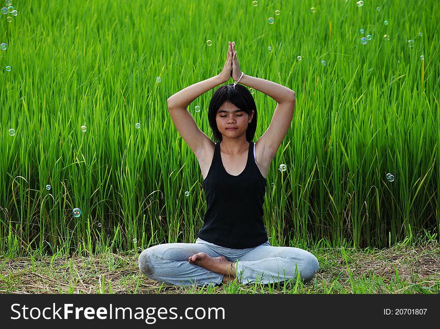 Girl practicing yoga, sitting in paddy field. Girl practicing yoga, sitting in paddy field