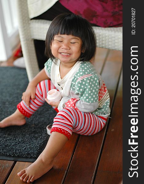 Little asian girl smiling and close eye