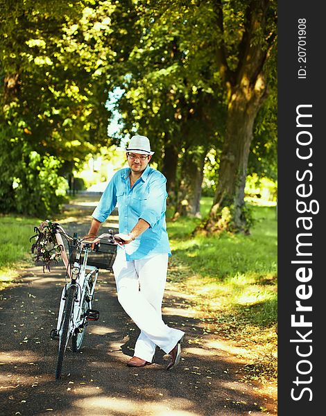 Romantic man standing with bicycle in the park