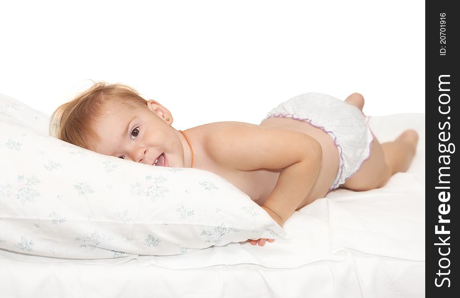 Beautiful baby lays on a white pillow. Beautiful baby lays on a white pillow