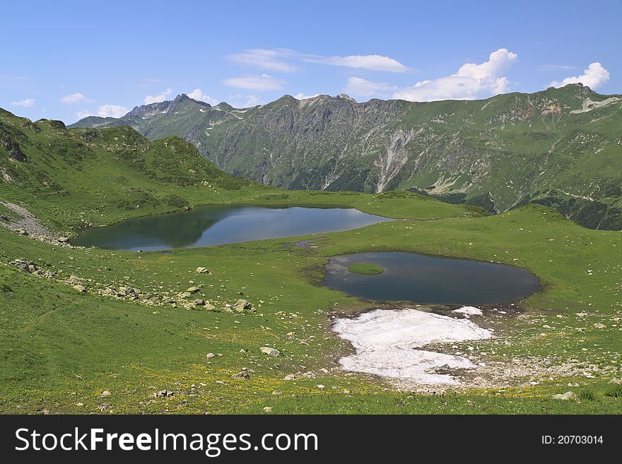 Snow lying at mountain lake in summer season