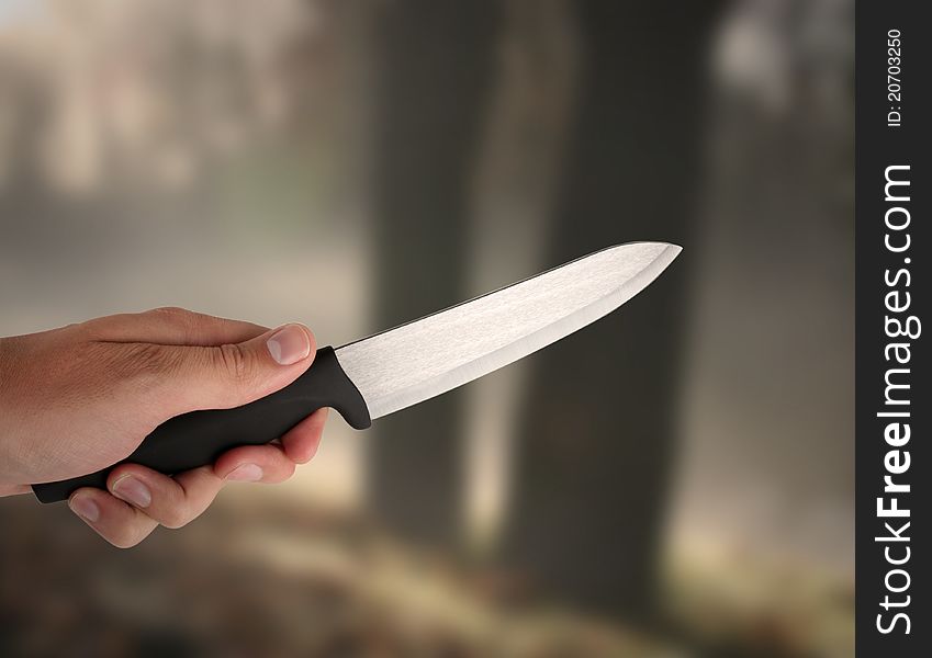 Hand holding knive - in a background dark wood. Hand holding knive - in a background dark wood