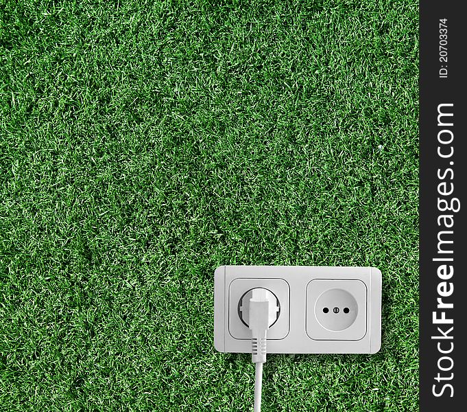 Plug and socket on the grass. Plug and socket on the grass