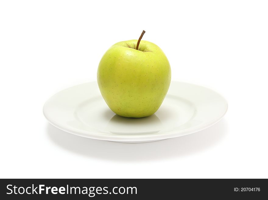 Green apple on the white plate