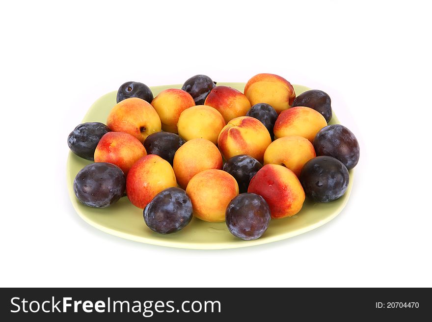 Still life with natural ripe plums and peaches on a white background