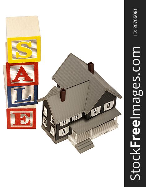 House model next to blocks spelling out the word sale. House model next to blocks spelling out the word sale.