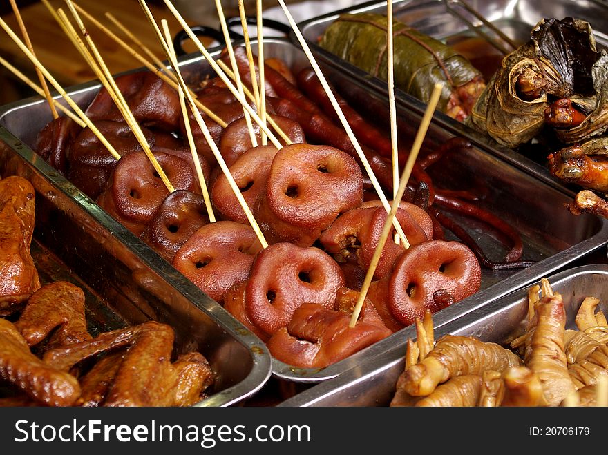 A stall selling pig snout on a stick. A stall selling pig snout on a stick