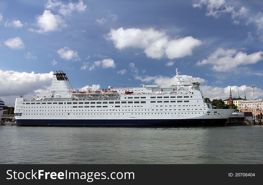 Passenger ship in port. The calm wave and cloudy sky.