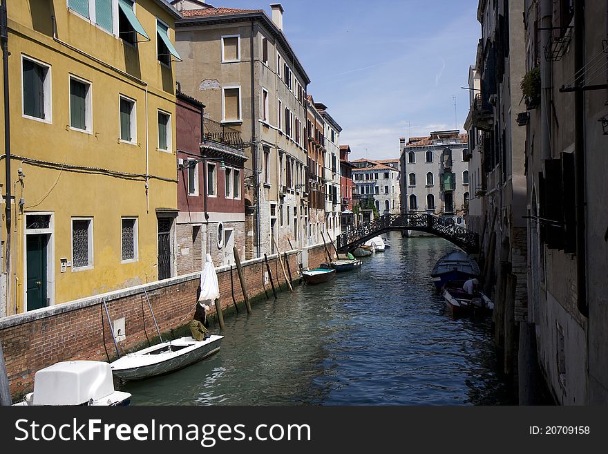 Buildings on a canal of Venice, and parked boats in Italy. Buildings on a canal of Venice, and parked boats in Italy