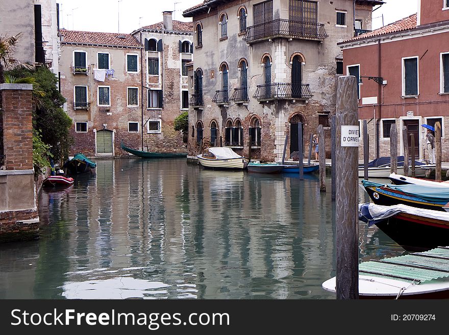 Buildings on a canal of Venice, and parked boats in Italy. Buildings on a canal of Venice, and parked boats in Italy