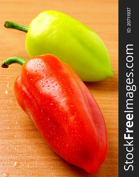 Raw ripe peppers on a wooden table. Raw ripe peppers on a wooden table