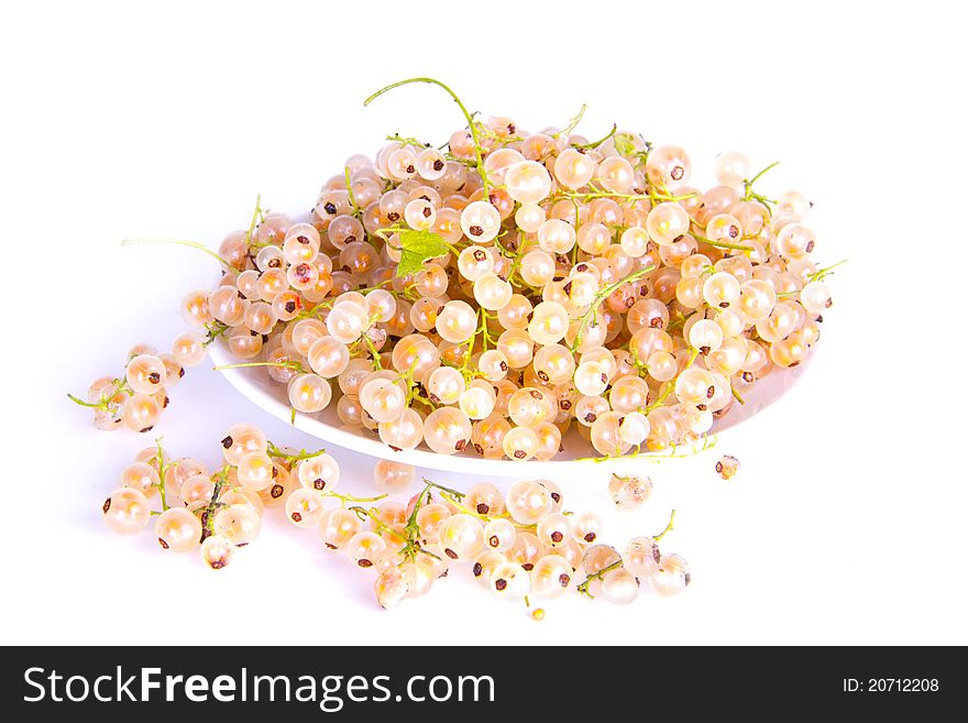 White currants lying on a plate on a white isolated background