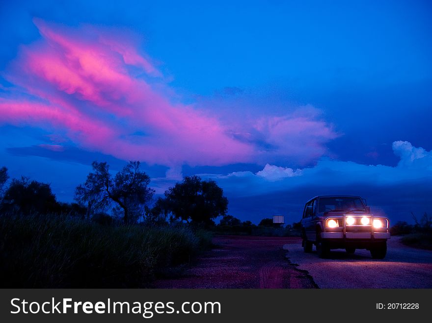 Car with headlamps at sunset in the middle of nowhere. Car with headlamps at sunset in the middle of nowhere