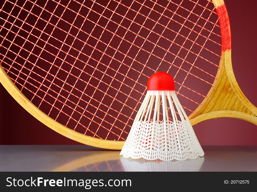 Shuttlecock and racket badminton on a red background