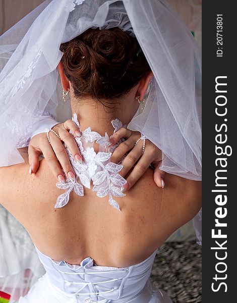 Bride's back with her hands on a neck
