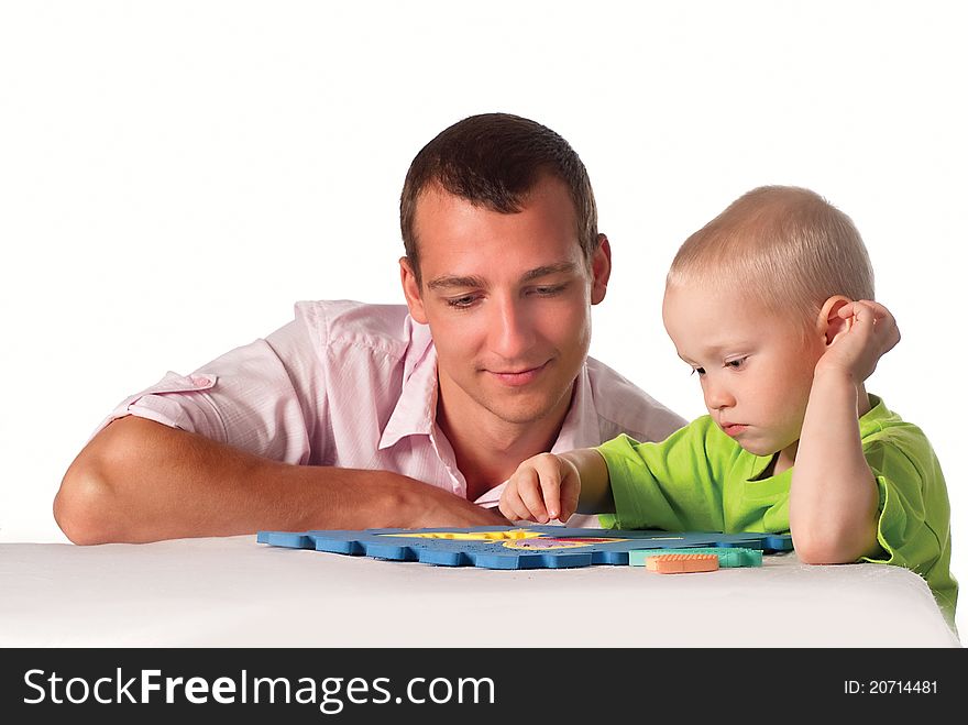 Smart dad and his son play at table. Smart dad and his son play at table