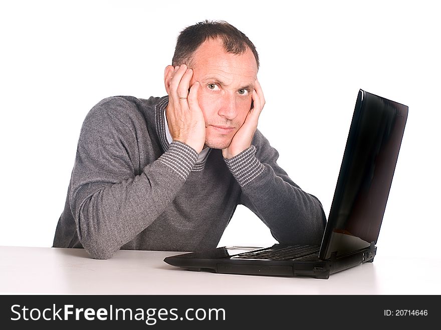 Man with computer sits at table on white. Man with computer sits at table on white