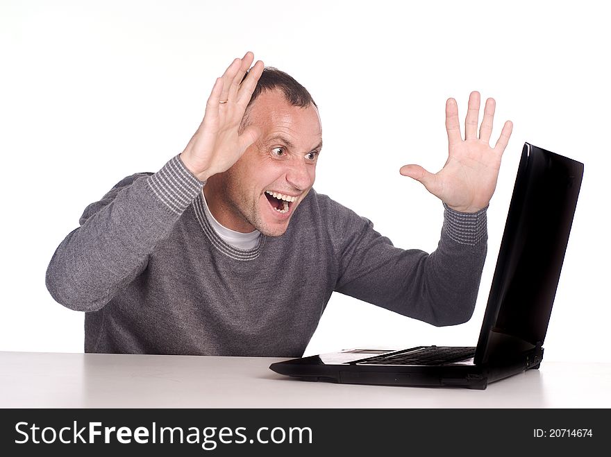 Man with computer sits at table on white. Man with computer sits at table on white