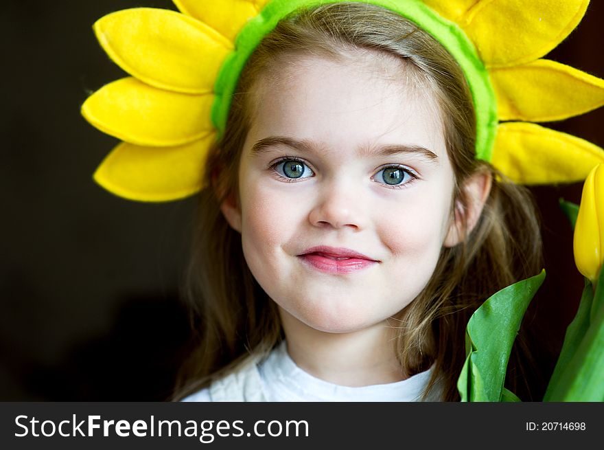 Sunny child girl with yellow crown on dark background. Sunny child girl with yellow crown on dark background