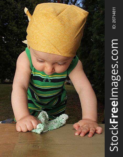 Cute baby boy outside in the garden wearing green outfit. Cute baby boy outside in the garden wearing green outfit