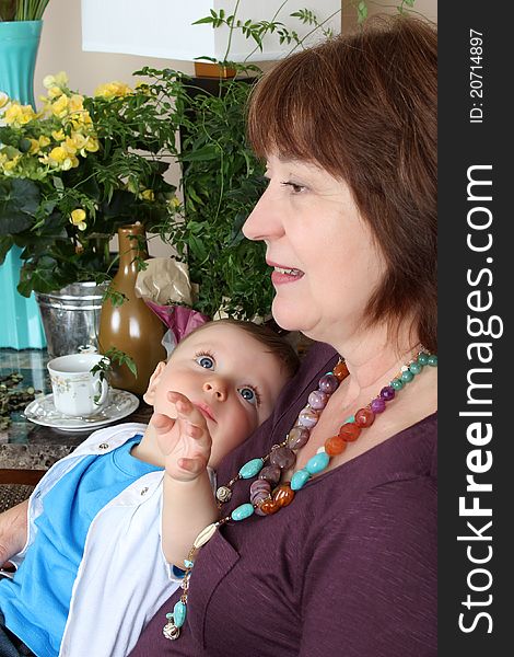 Beautiful baby boy sitting by his grandmother. Beautiful baby boy sitting by his grandmother