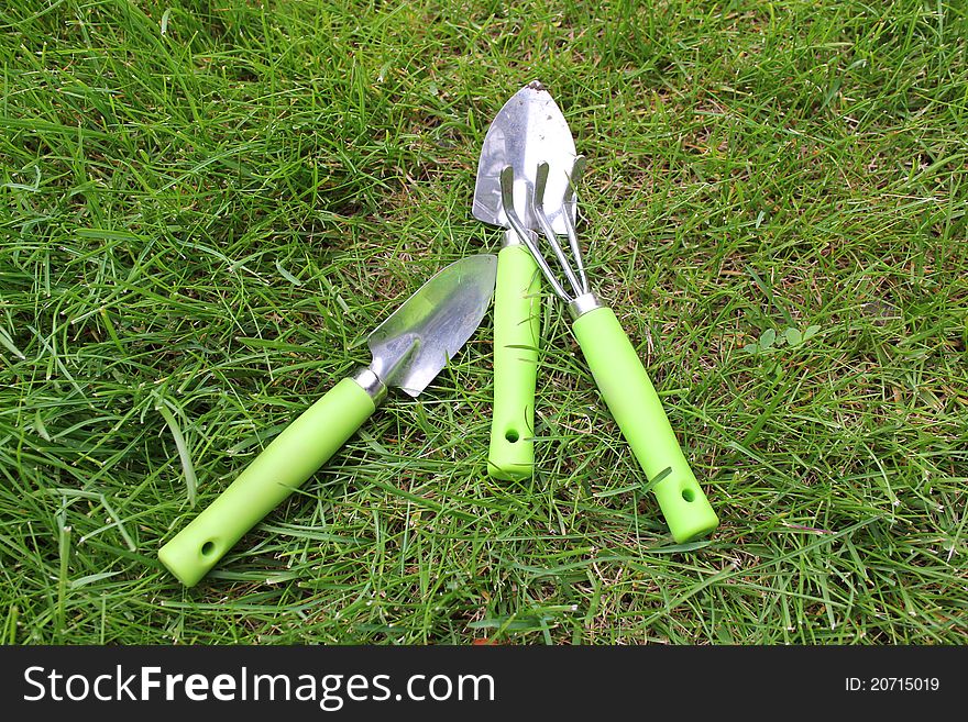 Three child sized garden tools on grass. Three child sized garden tools on grass