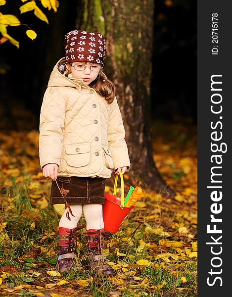 Cute toddler girl walks in autumn forest