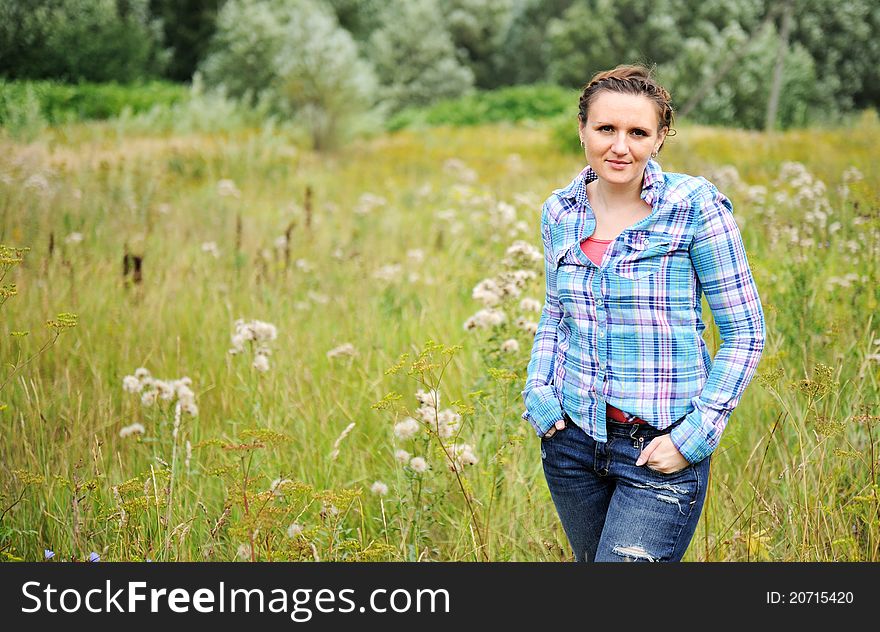 Young Pretty Woman Poses Standing In The Meadow