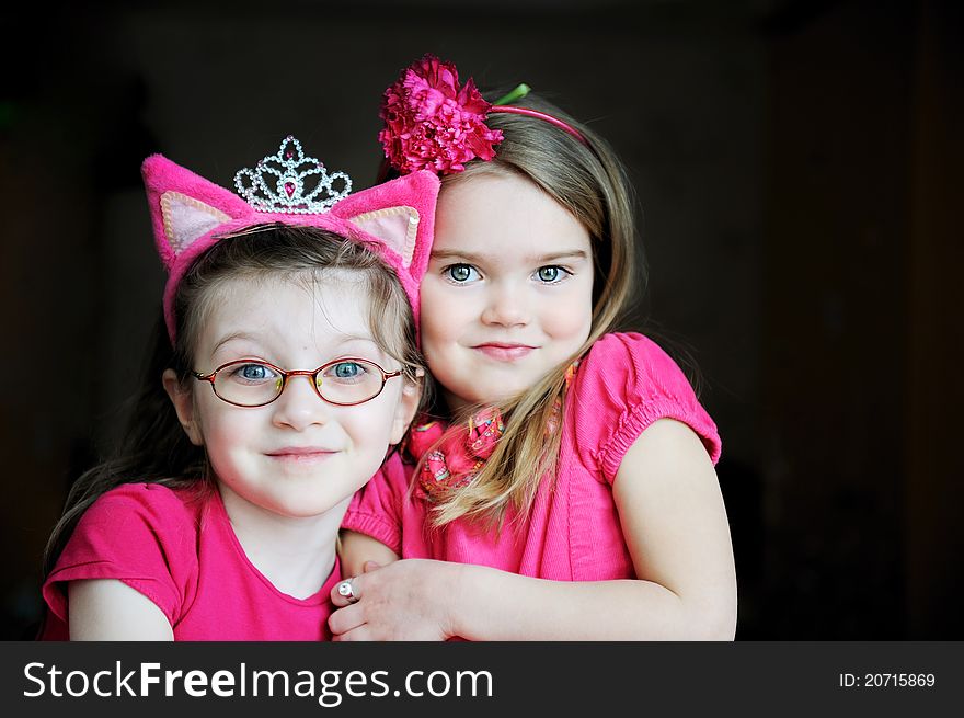 Portrait of two pinky child girls on black background