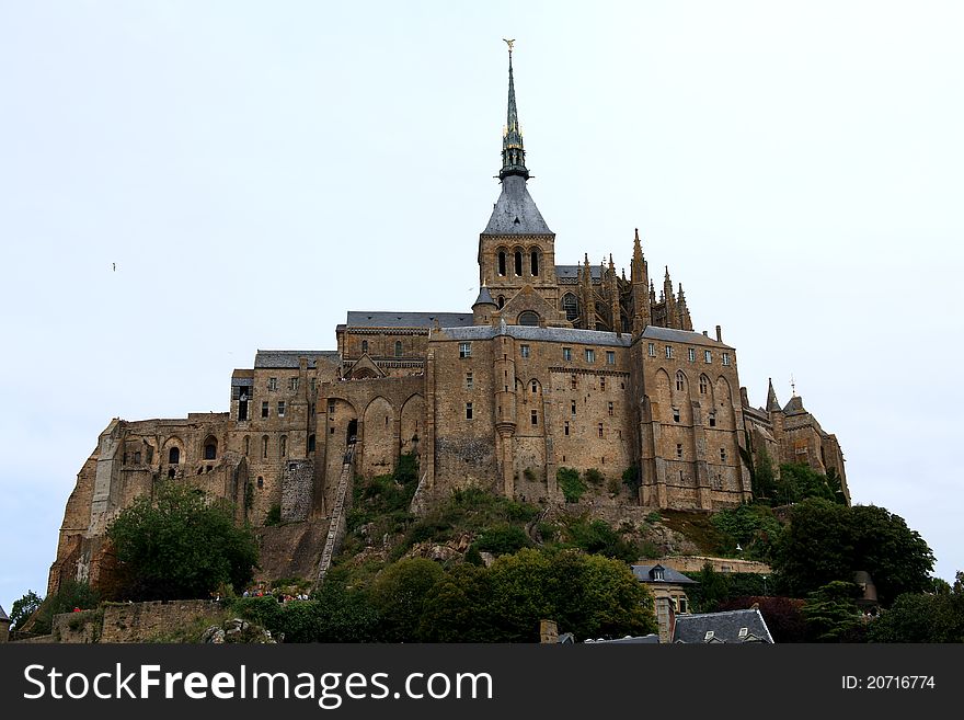 Mont Saint-Michel is a rocky tidal island and a commune in Normandy, France. It is located approximately one kilometre off the country's north-western coast, at the mouth of the Couesnon River near Avranches. The population of the island is 41, as of 2006. The island has been a strategic point holding fortifications since ancient times, and since the 8th century AD it became the seat of the Saint-Michel monastery, from which it draws the name.