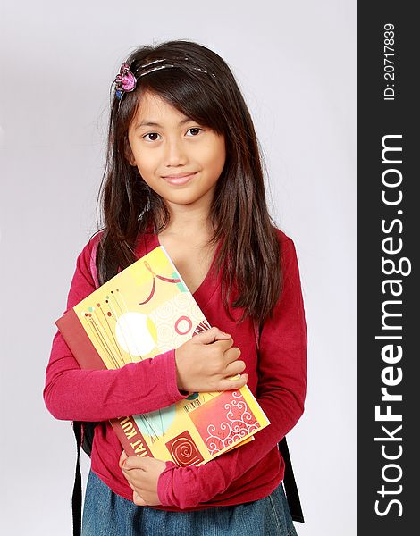 Portrait Of Girl Smiling With Backpack And Books