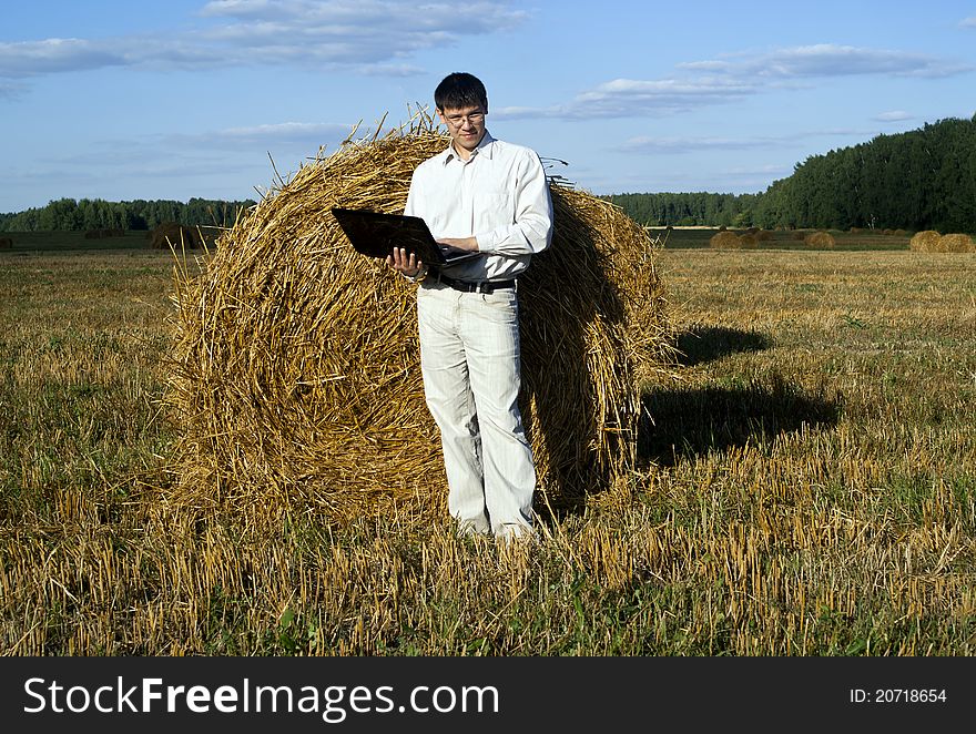 Business man with laptop at the field