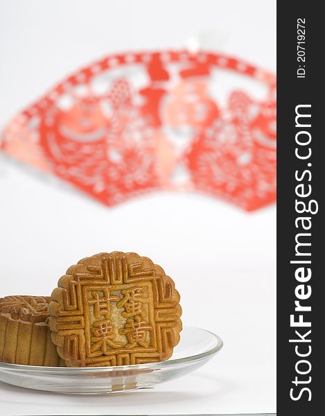 Chinese moon cakes on a plate with Chinese paper cutting background