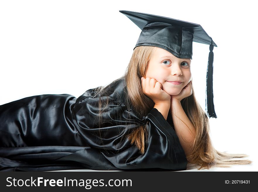 Portrait of smiling cute girl in black academic cap and gown lying on isolated white. Portrait of smiling cute girl in black academic cap and gown lying on isolated white