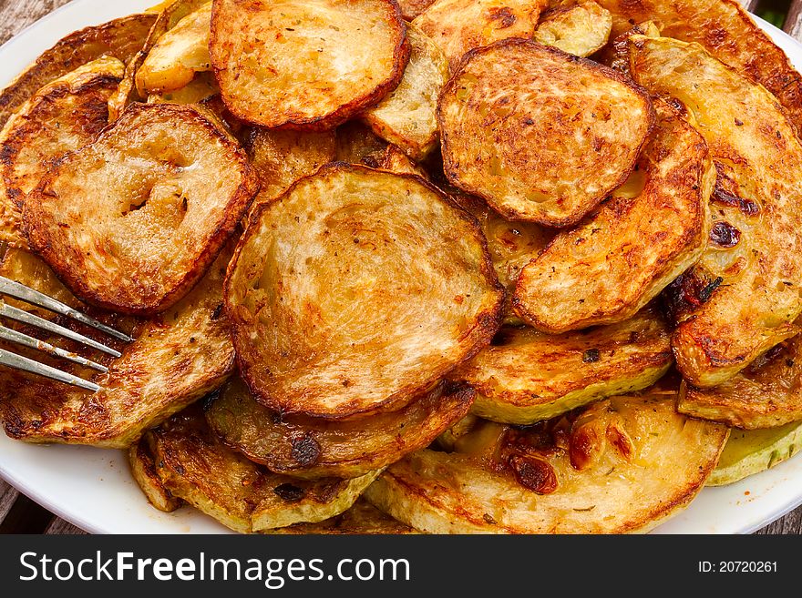 Fried zucchini with garlic closeup on a plate