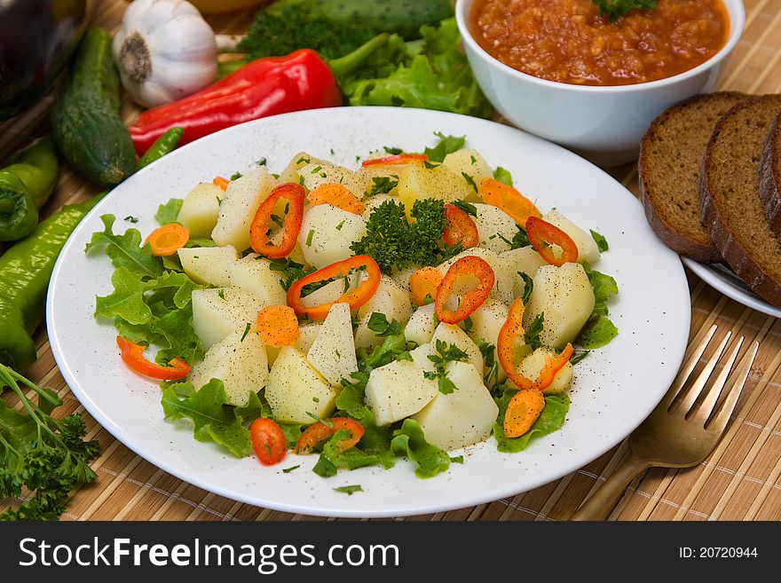 Boiled potatoes with vegetables on white plate