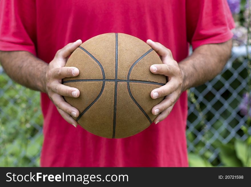 Poor player holding his very old basketball.