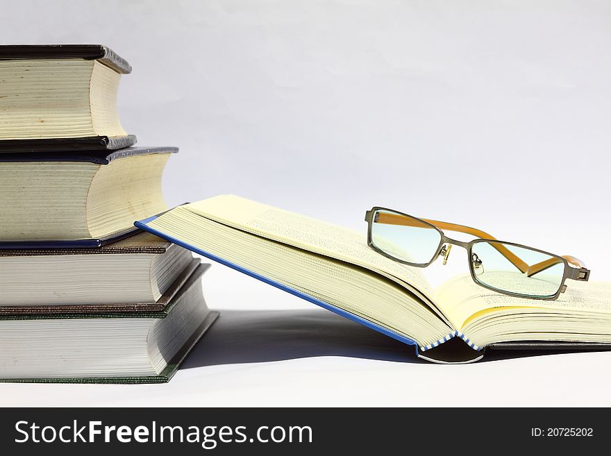 Book open and a glasses on white background. Book open and a glasses on white background