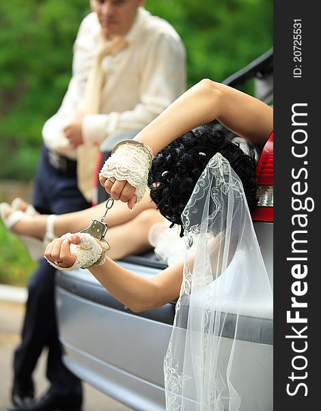 Groom discharging of captive bride from car trunk. Groom discharging of captive bride from car trunk